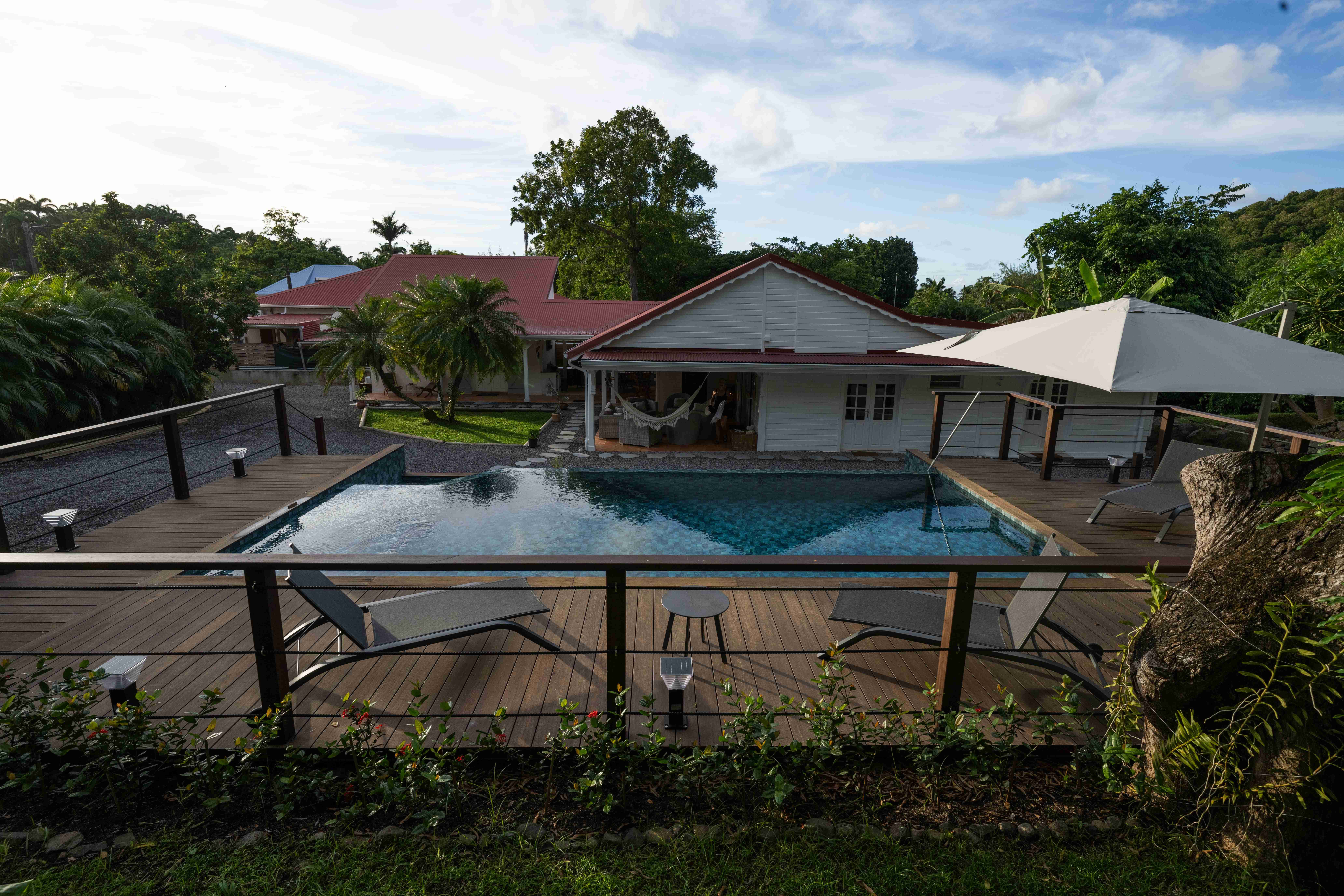 Piscine turquoise entourée d'un deck avec transats